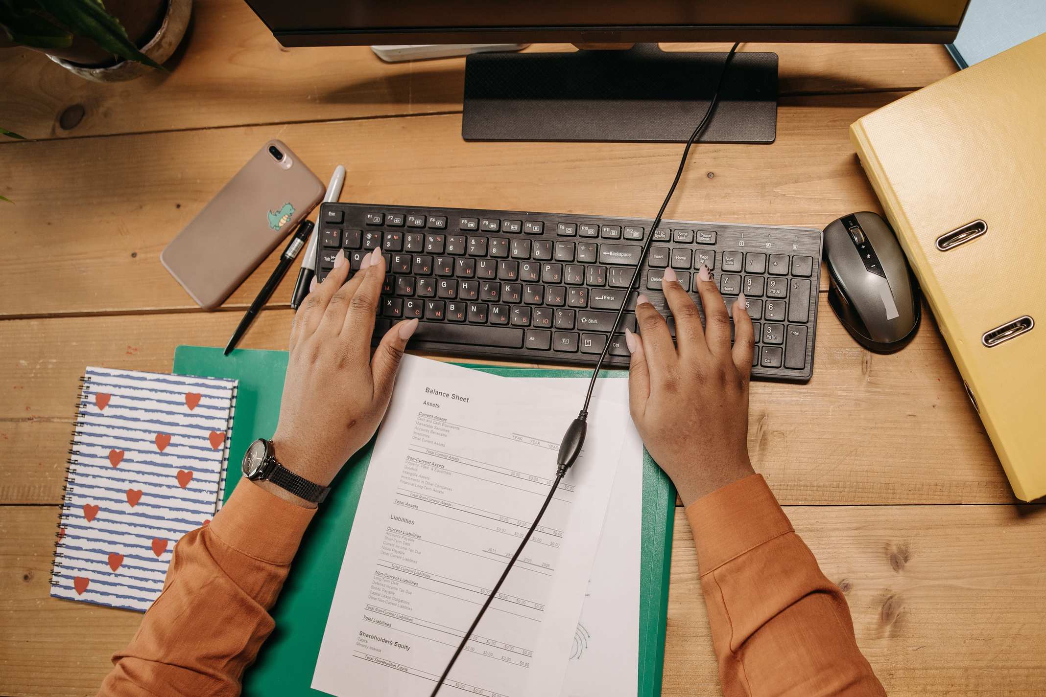 Overhead view of a desk workspace with keyboard and office supplies